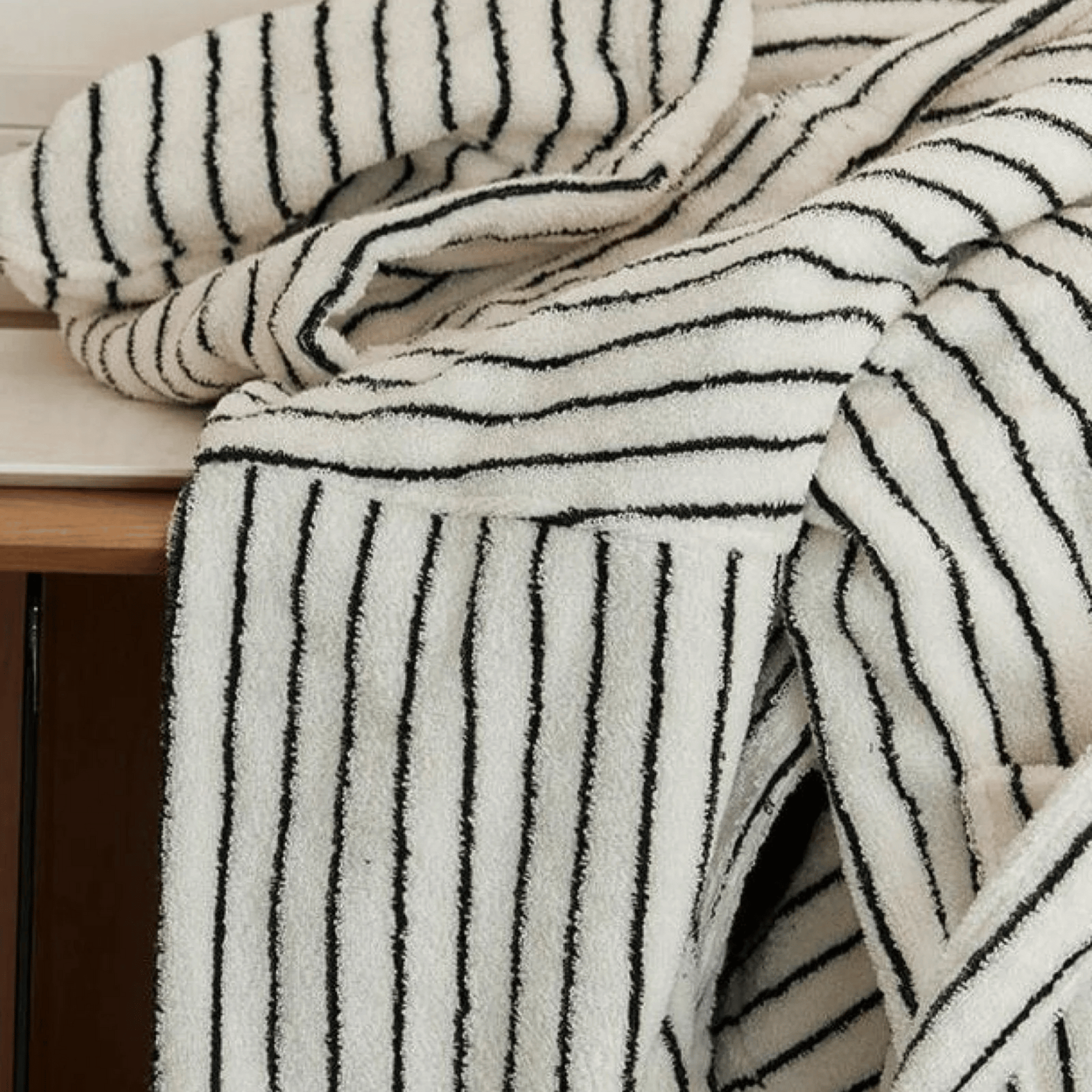 Black and white striped towel draped over a wooden surface