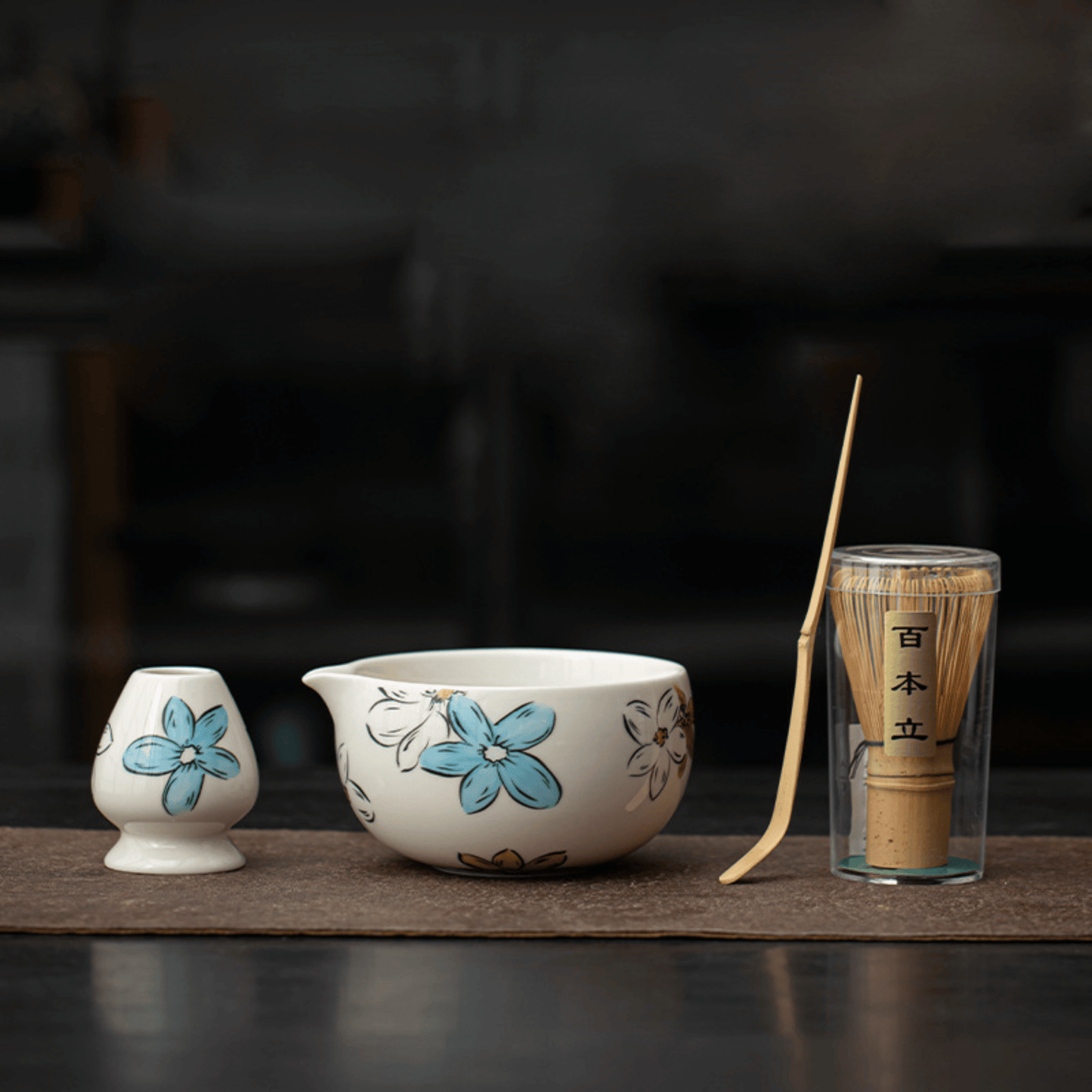 Ceramic tea set with floral design on a dark background