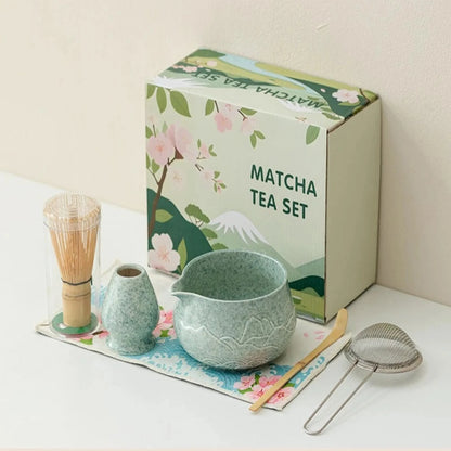 Matcha tea set with a green box featuring matcha-themed illustrations on a white surface.
