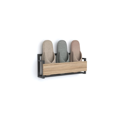 A stylish wall-mounted slipper rack with a black metal frame and a wooden front panel, neatly holding three pairs of slippers in beige, gray, and pink.